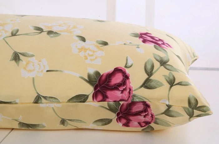 Floral-patterned pillow with pink roses on a light yellow background
