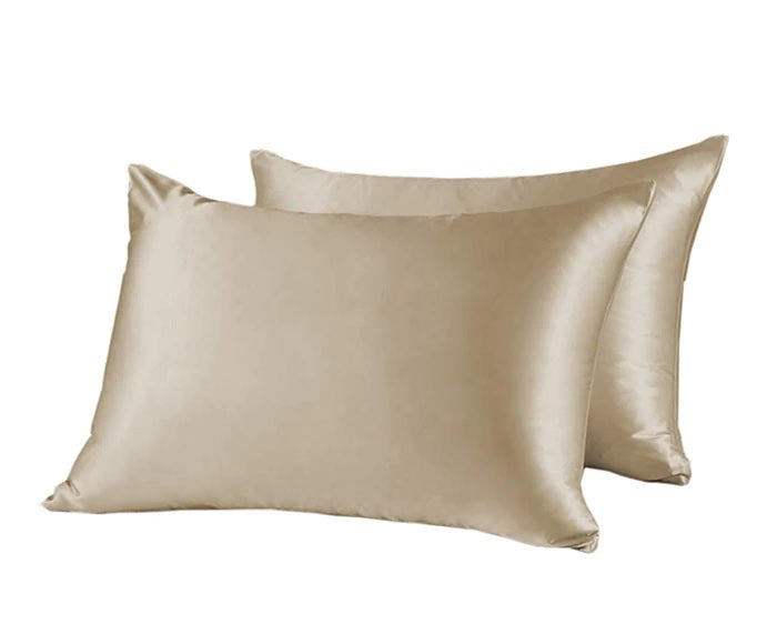 Two beige satin pillowcases on a white background