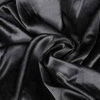 Close-up of black satin fabric with folds