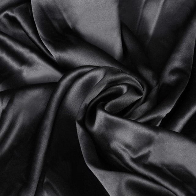 Close-up of black satin fabric with folds