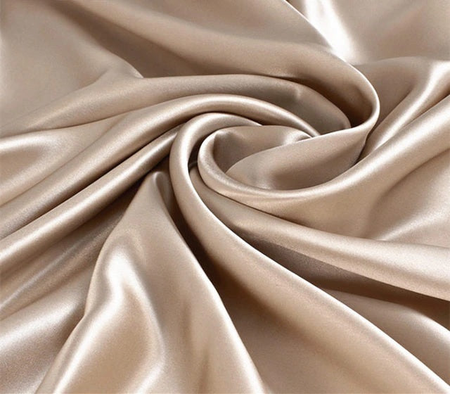 Close-up of beige satin fabric with folds