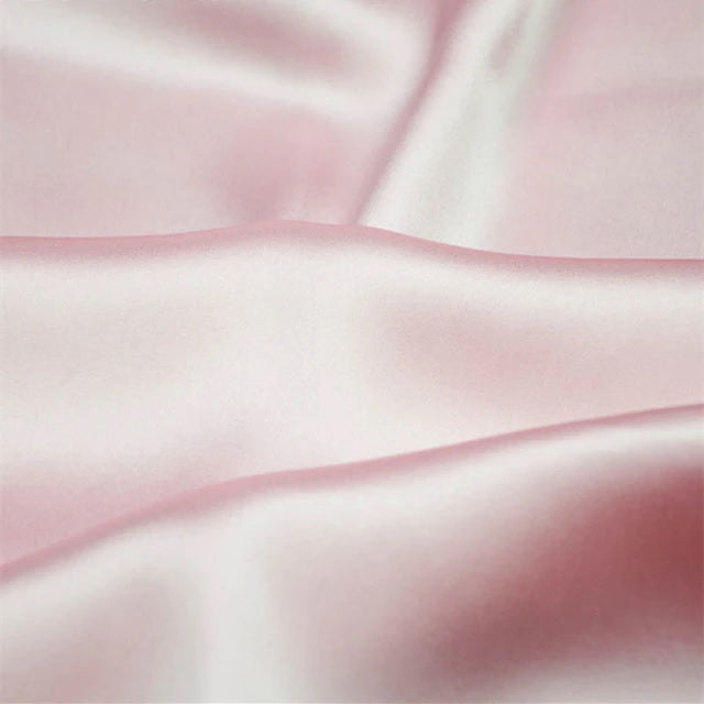 Close-up of pink satin fabric with a soft texture