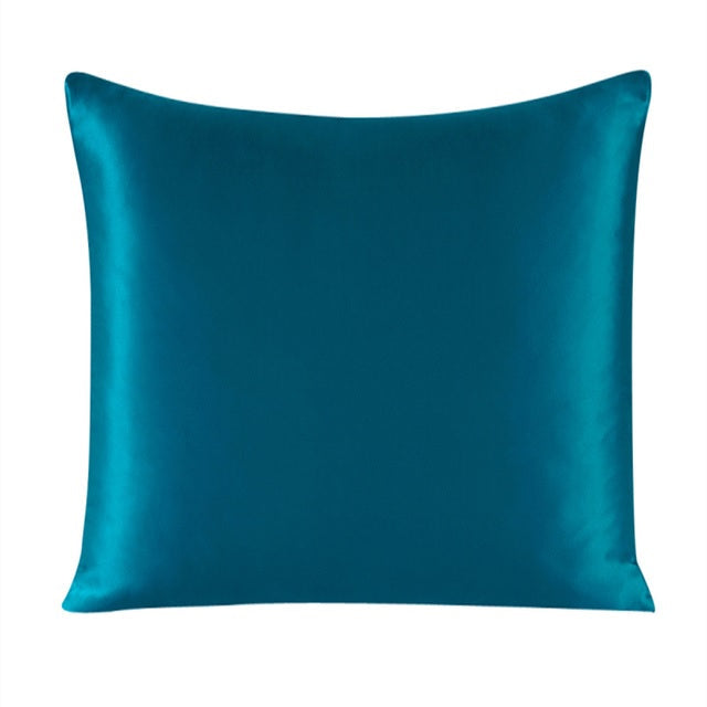 Teal satin pillow on a white background