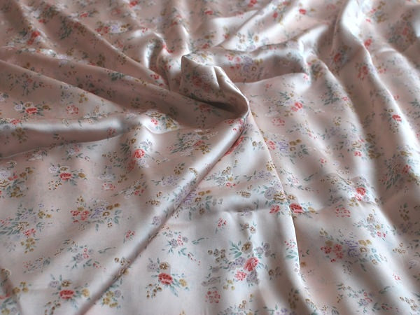 Floral fabric with small patterns on a light pink background